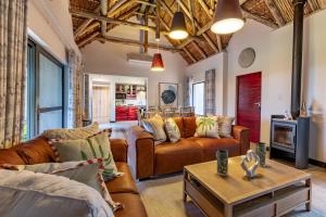 a living room with two couches and a table at Phelwana Game Lodge in Hoedspruit