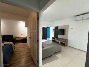 a room with a bed and a couch and a television at Apart Lunge in Córdoba