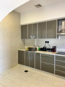 a kitchen with gray cabinets and a tile floor at IN 2 Chalet in Jeddah