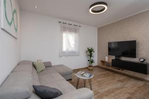 a living room with a couch and a flat screen tv at House Hana 2415 in Vodnjan