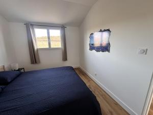a bedroom with a blue bed and a window at L'abeille sous les étoiles in Saint-Michel-lʼObservatoire +23 photos
