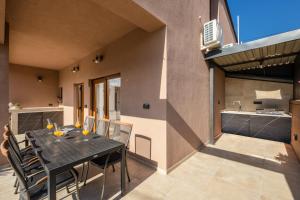 a dining room with a table and chairs on a patio at House Hana 2415 in Vodnjan