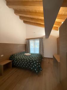 a bedroom with a bed and a window at Locanda Baita Donariè in San Vito di Cadore