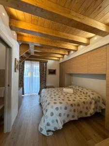a bedroom with a large bed and wooden ceilings at Locanda Baita Donariè in San Vito di Cadore