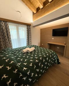 a bedroom with a bed with a black blanket with stars at Locanda Baita Donariè in San Vito di Cadore