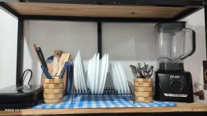 a shelf with a bunch of utensils and a blender at House Duque de Caxias in Duque de Caxias