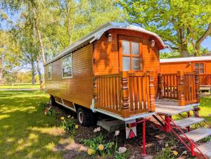 a wooden tiny house on a trailer in a field at Schloss Sigrön Zirkuswagen in Bad Wilsnack