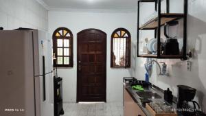 a kitchen with a brown door and a refrigerator at House Duque de Caxias in Duque de Caxias
