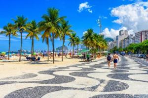 a group of people walking on a beach with palm trees at House Duque de Caxias in Duque de Caxias
