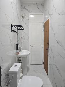 a white bathroom with a toilet and a sink at Green Zen Studio Metro 15 mins walk away in Dubai +25 photos