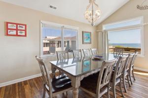 a dining room with a glass table and chairs at 7081 - Southern Breeze in Nags Head