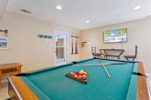 a pool table in a living room with a bowl of balls at 7081 - Southern Breeze in Nags Head