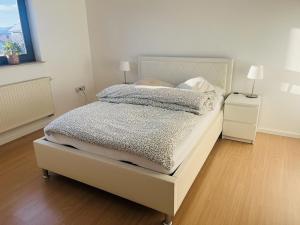 a bedroom with a bed and a night stand with two lamps at Ferienwohnung in Wörnitz in Unterwörnitz