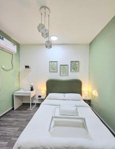a bedroom with two beds and a green wall at Green Zen Studio Metro 15 mins walk away in Dubai