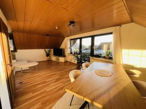 a living room with a wooden table and a large window at Ferienwohnung in Wörnitz in Unterwörnitz +1 photo