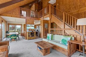 a large living room with wooden walls and a staircase at 1245 - Castle Sween in Corolla