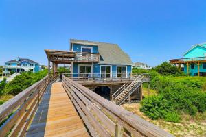 a house on a boardwalk in front of a house at 1245 - Castle Sween in Corolla