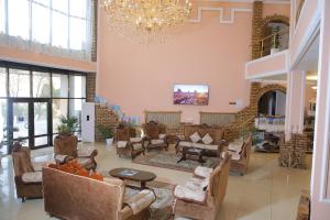 a living room with couches and chairs and a chandelier at Hotel Asia Khiva in Khiva
