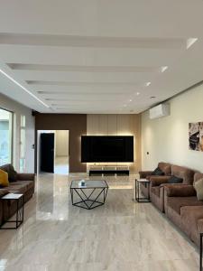 a living room with couches and a flat screen tv at IN 2 Chalet in Jeddah