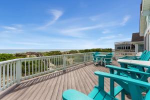a deck with blue chairs and tables and the ocean at 1398 - Alotta Coladas in Corolla