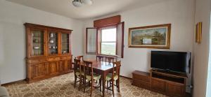 a dining room with a table and a television at Il Trebbiatore in San Costanzo