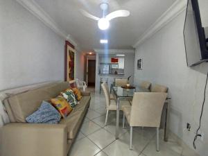 a living room with a couch and a dining room at Diamante guarapari in Guarapari