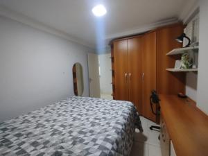 a bedroom with a bed and a wooden cabinet at Diamante guarapari in Guarapari