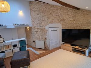 a living room with a large flat screen tv at L'estrade des Alpes 45m2 petit-déjeuner inclus in Saint-Alban-de-Roche