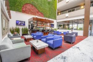 a lobby with blue couches and a bar at Best Western Plus Santa Cecilia Pachuca in Pachuca de Soto