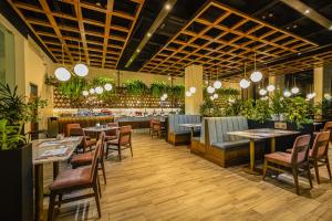 a restaurant with tables and chairs and plants at Best Western Plus Santa Cecilia Pachuca in Pachuca de Soto