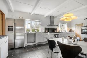 a kitchen with a table and some chairs in it at 20426-Samso-Nylandsvej-21 in Ballen