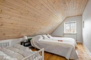 a bedroom with a large bed and a wooden ceiling at 20426-Samso-Nylandsvej-21 in Ballen