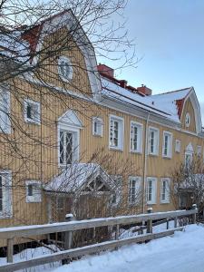a large wooden building with snow on the ground at Skolmästarevägen Åldersgräns 30 in Falun
