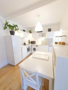 a kitchen with white cabinets and a white table at Hyper centre, quartier du port in Audierne