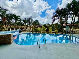 a large swimming pool with two surfboards in the middle at Hotel Wilson Upala in Upala