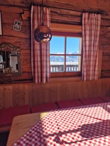 a room with a table and a window in a cabin at Faschingalm Loft in Lienz