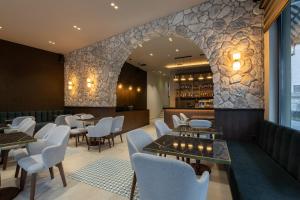 a restaurant with tables and chairs and a bar at Alkioni Boutique Hotel in Pýli