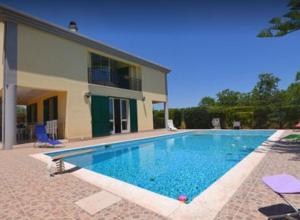 a swimming pool in front of a house at Villa Sara in Floridia