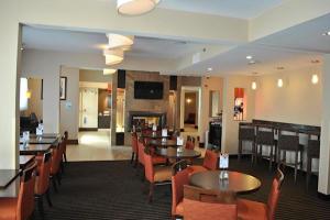 a restaurant with tables and chairs and a fireplace at Holiday Inn Express Pittsburgh - Munhall by IHG in Munhall