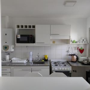 a kitchen with white cabinets and a stove top oven at departamento temporal 38 y 13 con cochera para AUTO in La Plata