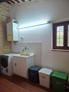 a kitchen with a sink and a washing machine at Villa Santa Maria in Montegiorgio