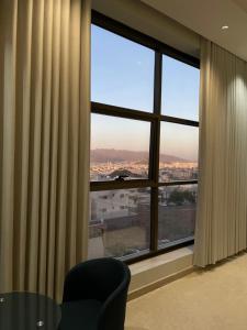 a room with a large window with a table and a chair at O2P Al Salam in Medina