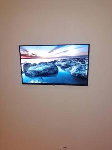 a flat screen tv hanging on a wall at Cutting Edge Guest House in Daranka