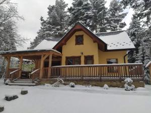 a house with a deck in the snow at Chaty Slovensky Raj Veronika in Smižany