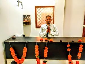a man adjusting his tie in front of a mirror at Hotel Venus in Jabalpur
