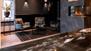 a lobby with two chairs and a fireplace at Hotel Middelburg in Middelburg