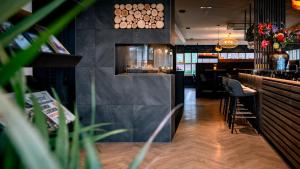 a bar in a restaurant with chairs and a counter at Hotel Middelburg in Middelburg