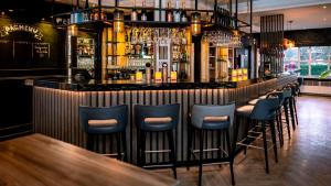 a bar with blue bar stools in a restaurant at Hotel Middelburg in Middelburg