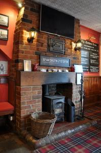 a brick fireplace with a television on top of it at The Clothiers Arms in Stroud +22 photos