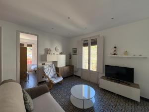 a living room with a couch and a tv at Apartamentos Nouvilas in Portbou